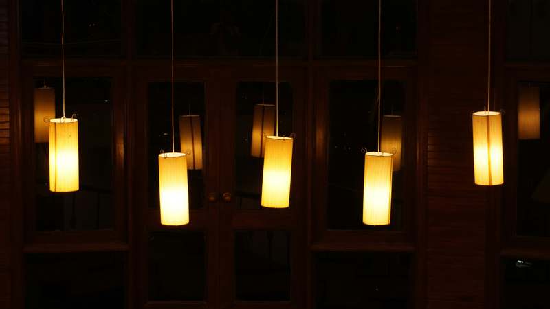 Warm pendant lights over a rustic wooden restaurant table with ambient dining ambiance